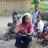 Baaka women and children in a village in Plateaux district, Republic of Congo, discussing an NGO project