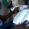 Un agent électoral cherche le nom d'un électeur lors du scrutin du 28 novembre 2010 en Haïti.