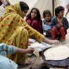 Flood victims gather around their meal at a tent camp in Quetta, Balochistan Province, Pakistan