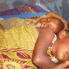 Children sleep under an insecticide-treated net which repels, disables and/or kills mosquitoes