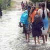 Des Sri Lankais affrontant les inondations.