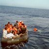 An Italian coastguard vessel rescues Tunisians afloat on a raft near Lampedusa