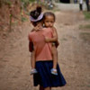 A young girl carries her brother in Maubara, Timor-Leste