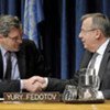 Alain Le Roy (left) and Yury Fedotov shake hands after signing pact to fight organized crime in conflict areas