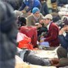 Bangladeshi man stranded at the Egyptian-Libyan border sits in  waiting hall after fleeing the violence