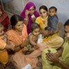 Mothers sitting on the floor with their children in India