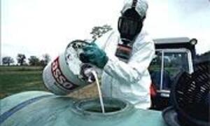 Un pesticide versé dans un réservoir avant d'être répandu dans un champ.