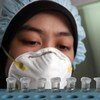 Una trabajadora de salud en Indonesia analiza muestras de sangre para detectar la gripe.