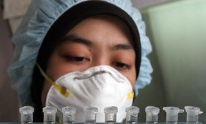 Indonesian health worker analyzing blood samples for influenza.