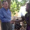 Fred Eckhard distributing bonuses to girls in Koudougou, Burkina Faso, aided by Gilberte Saint Cast's association