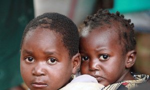 A child carries another on her back at a camp for IDPs in Nairobi, Kenya (2008).