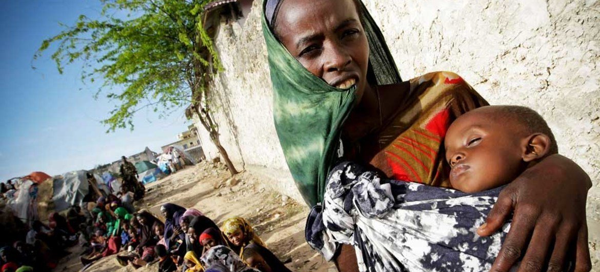 A Somali woman and her severely malnourished child wait for medical assistance from the African Union Mission in Somalia