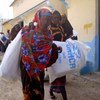 These displaced Somali women head back to their families carrying aid distributed in Mogadishu.