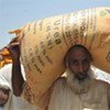 A farmer in Pakistan carries a sack of fertilizer provided by FAO