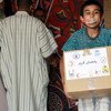 Un jeune réfugié transporte un carton de nourriture pour le repas du soir pendant le Ramadan.
