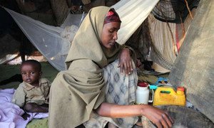 A refugee at camp Dabaad in Kenya prepares a meal for her family