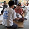 Un employé du HCR donne une couverture à une victime du cyclone Nargis qui a frappé le Myanmar en 2008.