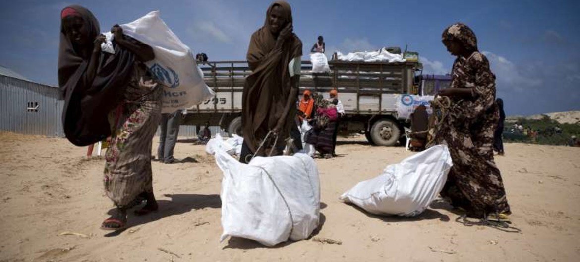 Internally displaced Somali women collect UNHCR aid supplies.