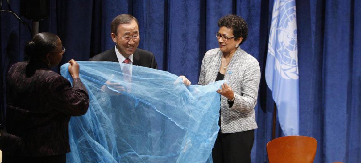 Le Secrétaire général Ban Ki-moon (au centre) déploie une moustiquaire permettant de lutter contre le paludisme. (13 septembre 2011)