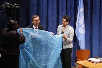 Le Secrétaire général Ban Ki-moon (au centre) déploie une moustiquaire permettant de lutter contre le paludisme. (13 septembre 2011)