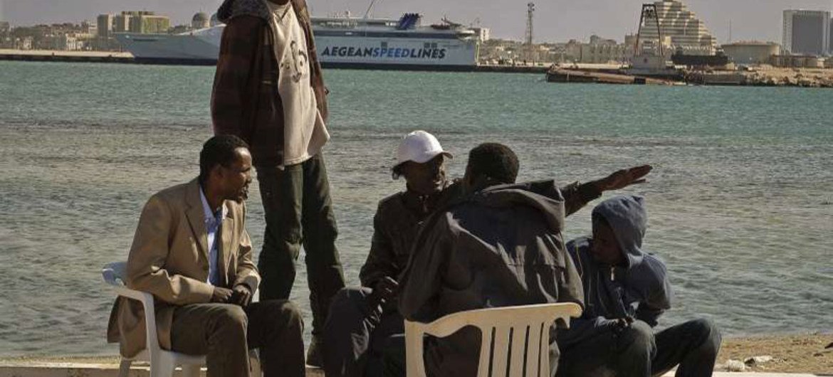 Migrant workers from sub-Saharan Africa sit by the sea in Benghazi, eastern Libya