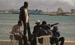 Migrant workers from sub-Saharan Africa sit by the sea in Benghazi, eastern Libya