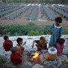 Des enfants préparent leur repas dans un des camps pour les personnes déplacées par des inondations au Pakistan en 2010.