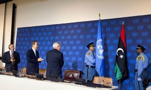 Secretary-General Ban Ki-moon (2nd left), Mustafa Mohammed Abdul Jalil (left), President of the National Transitional Council of Libya and B. Lynn Pascoe (centre) applaud as the new flag of Libya is brought in