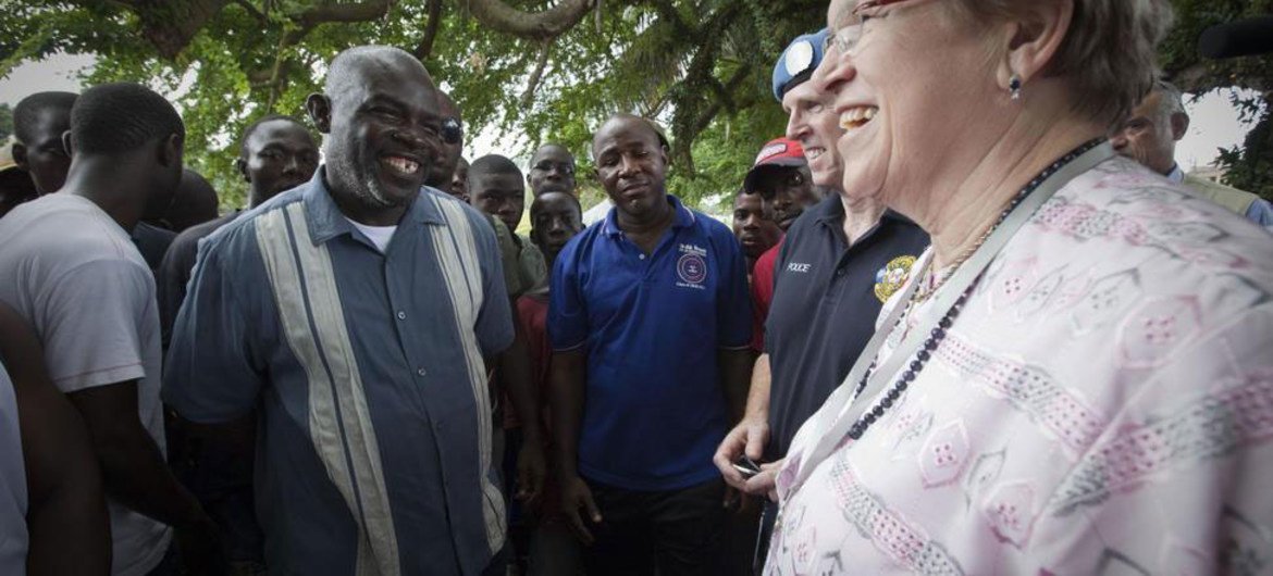 Special Representative for Liberia Ellen Margrethe Løj (right), speaks with voters outside a polling station during the run-off election.