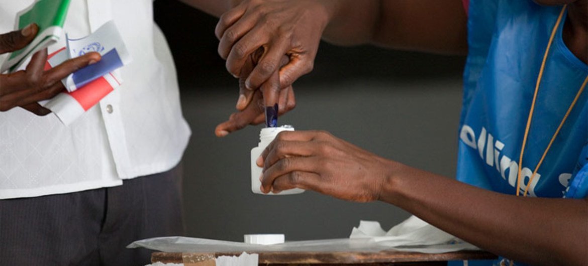 A man has his finger dipped in ink after voting in national elections in Liberia on 11 October 2011