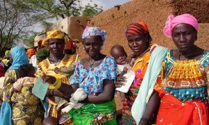 Mothers with hungry children lining up at distribution site in Taoa, Niger,  for food handouts