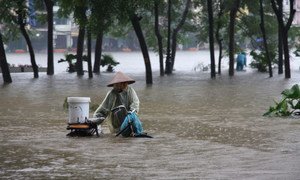 Une femme prise dans des inondations à Hanoï, au Viet Nam.