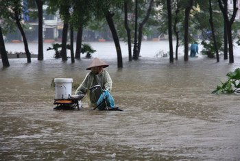 Une femme prise dans des inondations à Hanoï, au Viet Nam.