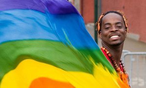 Un homme agite le drapeau arc-en-ciel, symbole international des droits des gays, lesbiennes, bisexuels et transgenres.
