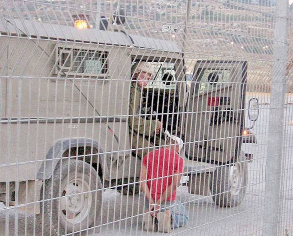 Un soldat israélien arrêtant un enfant palestinien âgé de 12 ans à un point de passage à Naplouse.