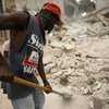 A man employed through the "Cash for Work" programme clears rubble from the streets of Carrefour-Feuilles, Haiti.