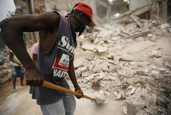 A man employed through the "Cash for Work" programme clears rubble from the streets of Carrefour-Feuilles, Haiti.