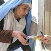 Une femme de Jalalabad reçoit un coupon-repas du PAM.