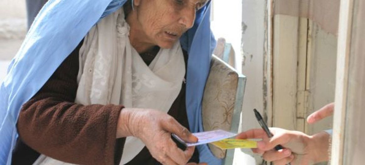 Une femme de Jalalabad reçoit un coupon-repas du PAM.