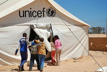 Children enter a UNICEF-supported tent school at the Shousha transit camp on the Libyan border