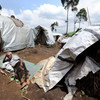 A woman forced to flee her home village rests outside a shelter in North Kivu province.