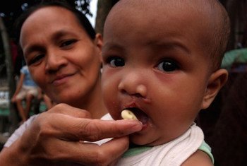A mother in Mindanao, Philippines, feeds her baby with high-protein paste during a feeding programme for survivors of tropical storm Washi.