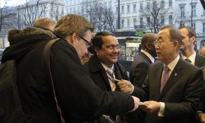 Secretary-General Ban Ki-moon (right) signs autographs for fans outside his hotel in Vienna, Austria.