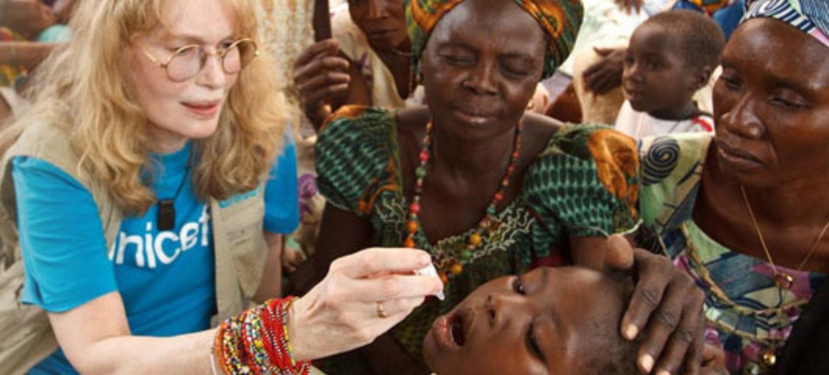Mia Farrow gives a boy a dose of oral polio vaccine at an immunisation site in Moundou, Chad.