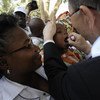 Ban Ki-moon administre un vaccin contre la polio à un bébé dans un centre de santé en Angola. Photo ONU/ E. Schneider