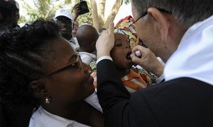 Secretary-General Ban Ki-moon administers polio medicine to a baby at a healthcare centre in Viana district, Angola in February 2012.