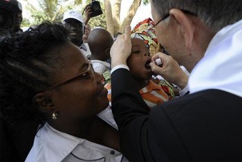 Secretary-General Ban Ki-moon administers polio medicine to a baby at a healthcare centre in Viana district, Angola in February 2012.