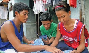 Un jeune homme explique la prévention contre le VIH/sida et d'autres maladies sexuellement transmissibles à Pasay City, aux Philippines. Photo UNICEF
