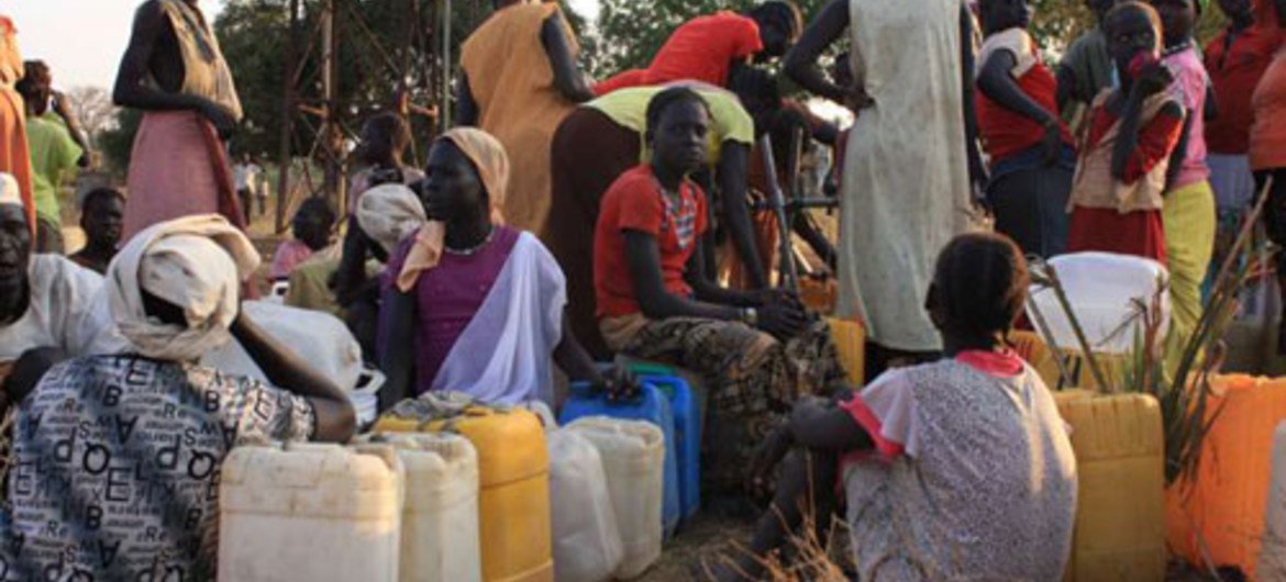 Sudanese refugees from Blue Nile state line up to collect water in a camp.