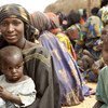 A Malian refugee mother with her children wait to receive relief items in Gaoudel, Ayorou district, northern Niger.